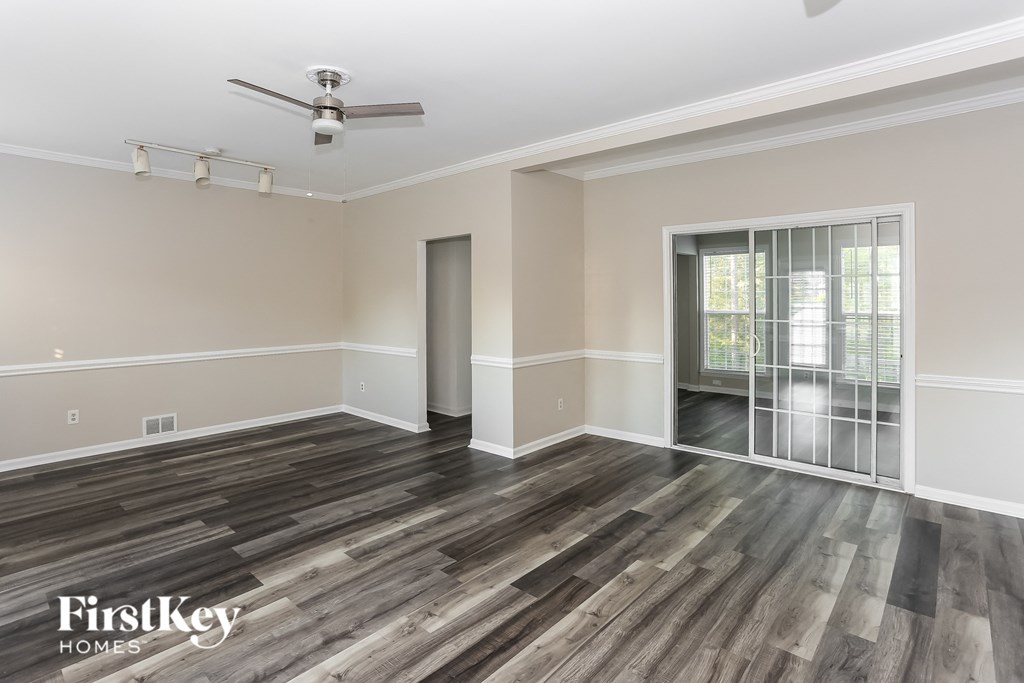 an empty living room with wood flooring and a sliding glass door