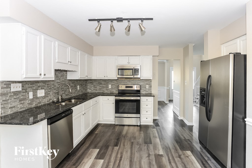 a kitchen with white cabinets and stainless steel appliances