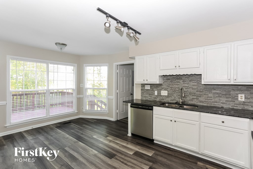 a kitchen with white cabinets and a counter top and a sink