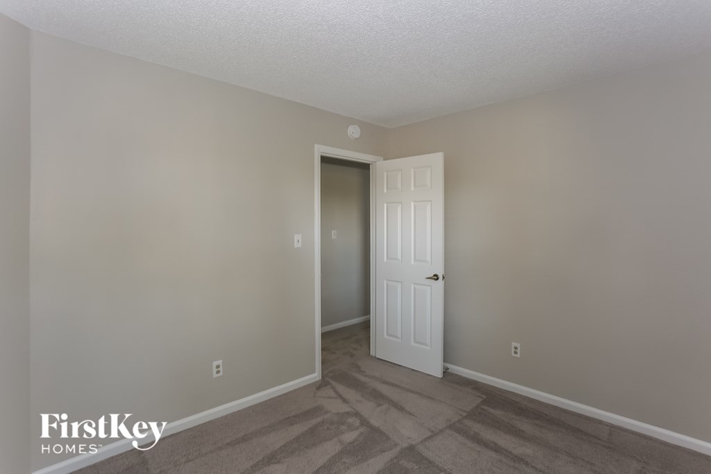 the living room of an apartment with a door to the closet