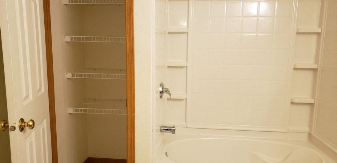 a white bathroom with a shower and a door