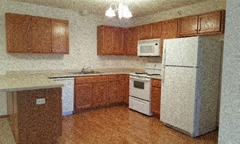 a kitchen with a white refrigerator and a microwave