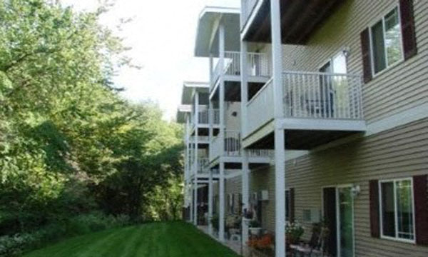 a view of the back of a house with a yard and a balcony