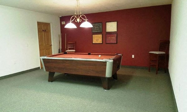 a pool table in a room with a red wall