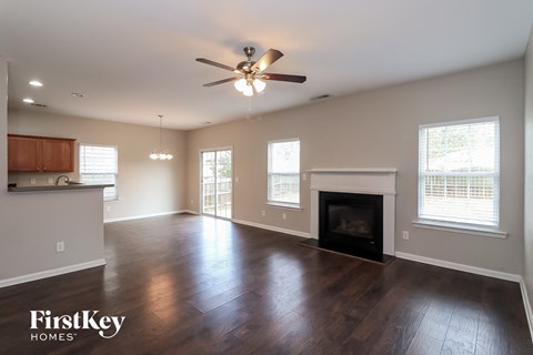A spacious living room with wood floors and a fireplace.