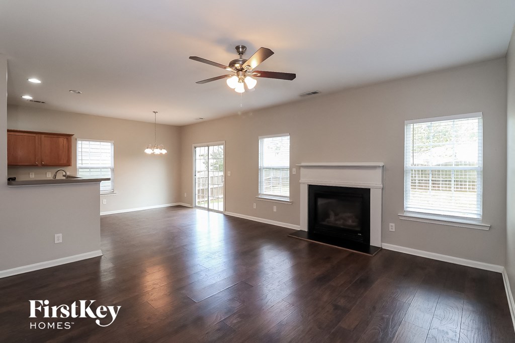 A spacious living room with wood floors and a fireplace.