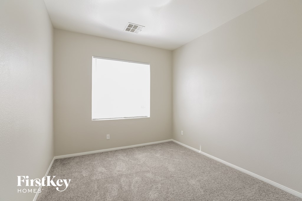 a empty room with a window and carpet