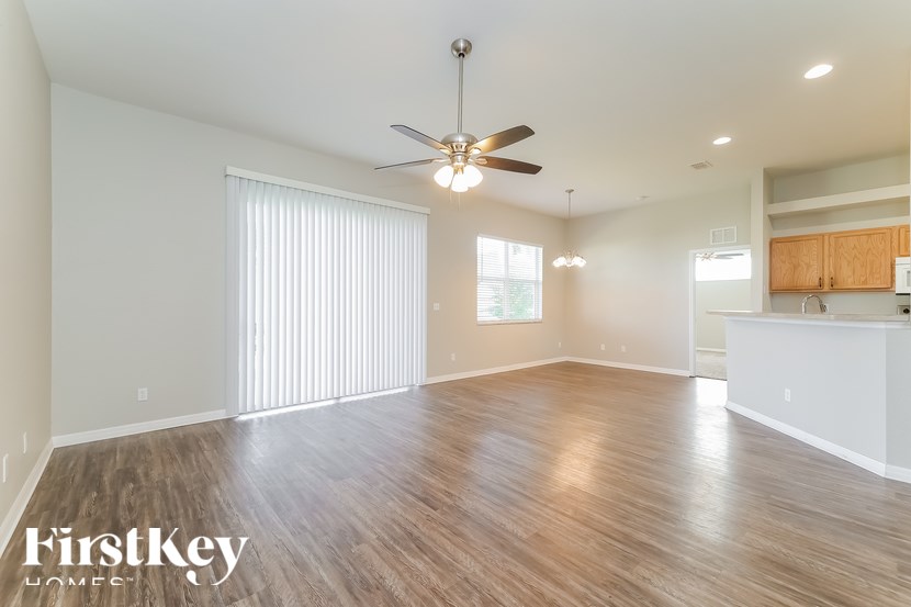 A spacious room with wooden flooring and a ceiling fan.