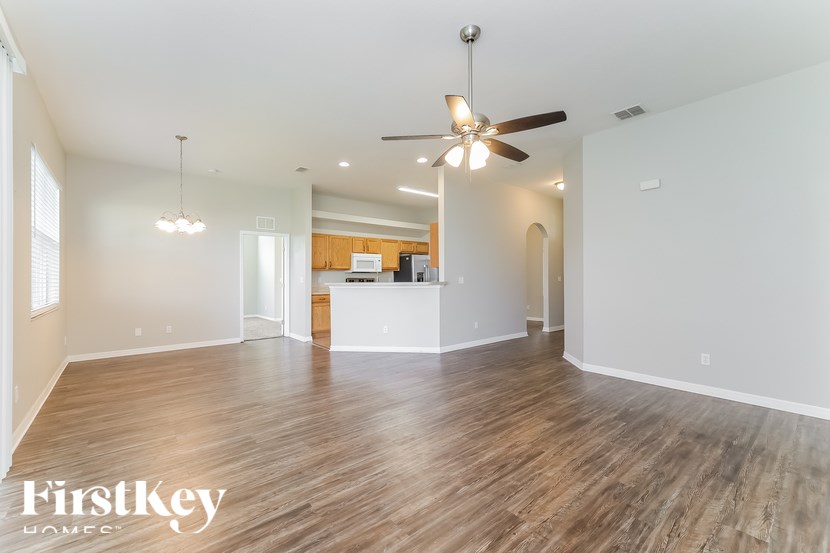 A spacious room with wooden flooring and a ceiling fan.