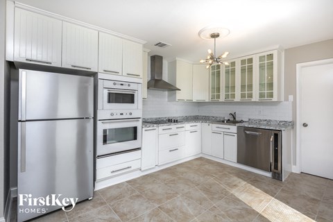 a white kitchen with stainless steel appliances and white cabinets