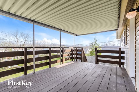 a spacious deck with a view of the mountains and trees