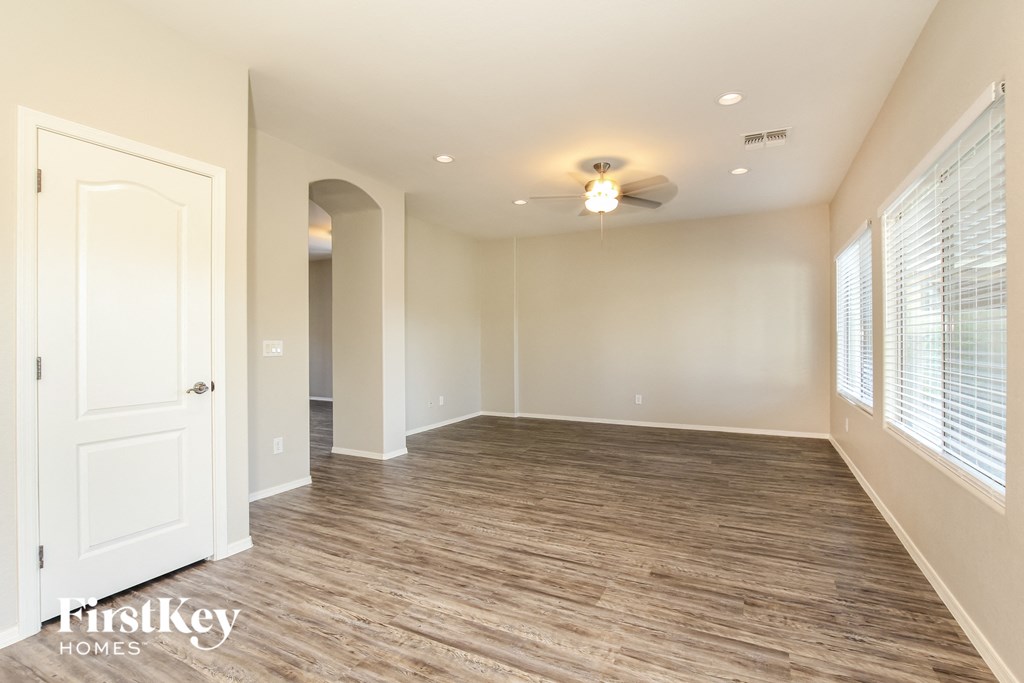 a living room with a white door and a ceiling fan