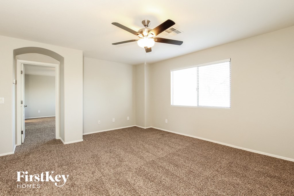 a bedroom with carpet and a ceiling fan