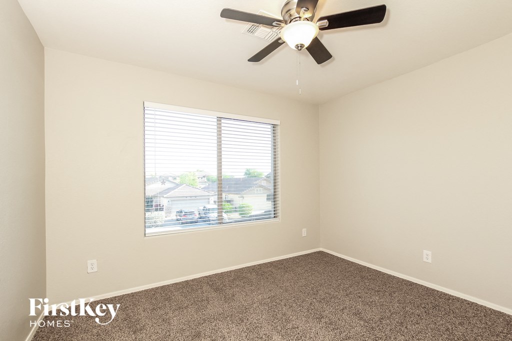 a bedroom with a ceiling fan and a window