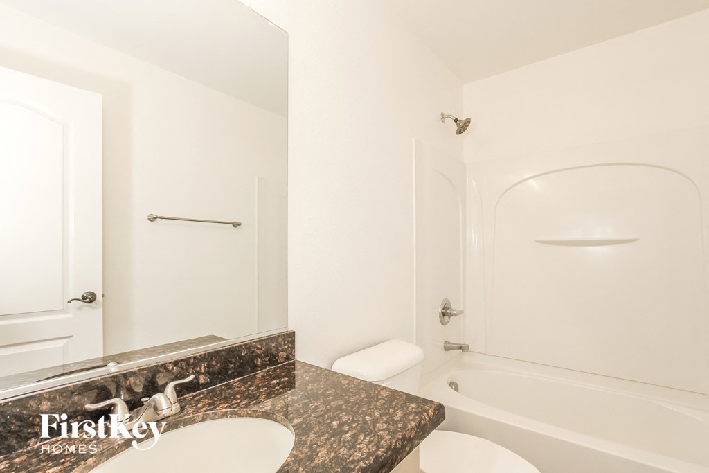 a bathroom with a sink and a toilet and a shower