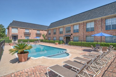 A pool surrounded by lounge chairs and umbrellas.