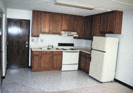 a kitchen with white appliances and wooden cabinets