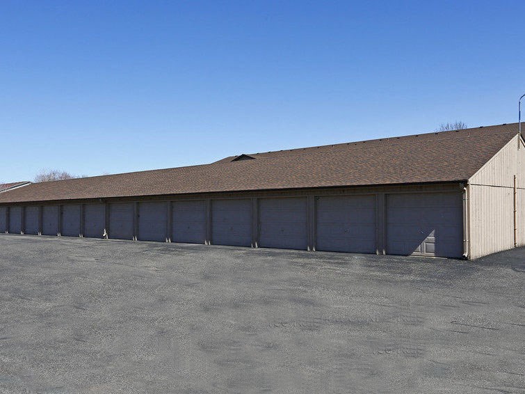 a long building with garage doors in a parking lot