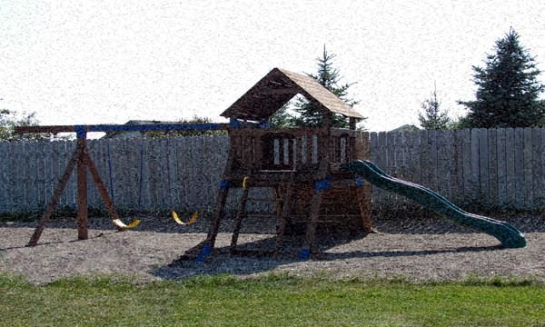 a swing set in a backyard next to a fence