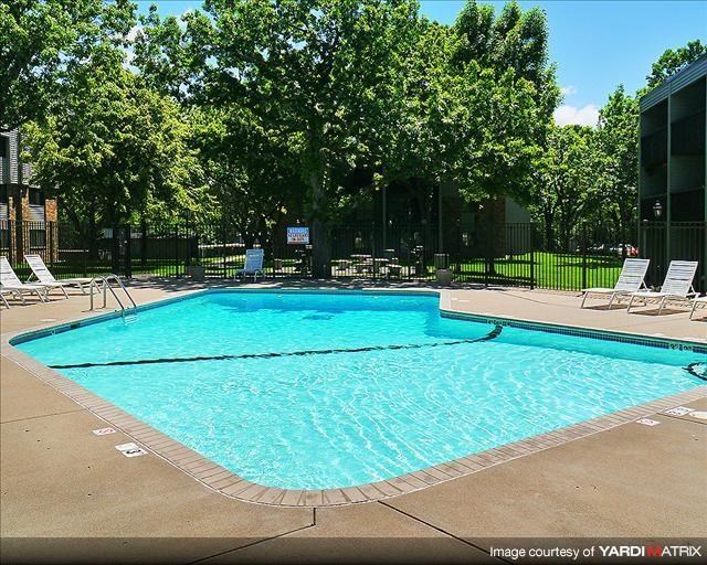 a swimming pool with white chairs around it
