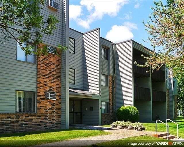 an apartment building with a sidewalk in front of it