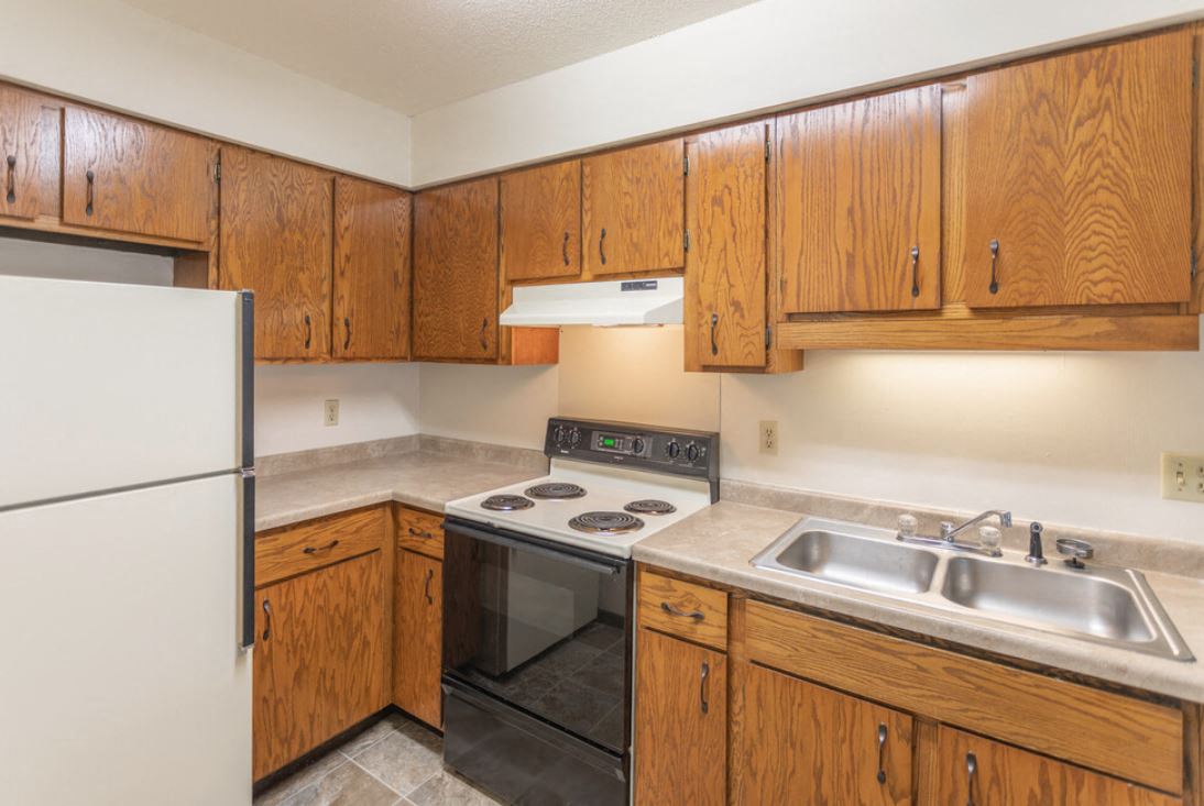 a kitchen with a stove refrigerator and sink