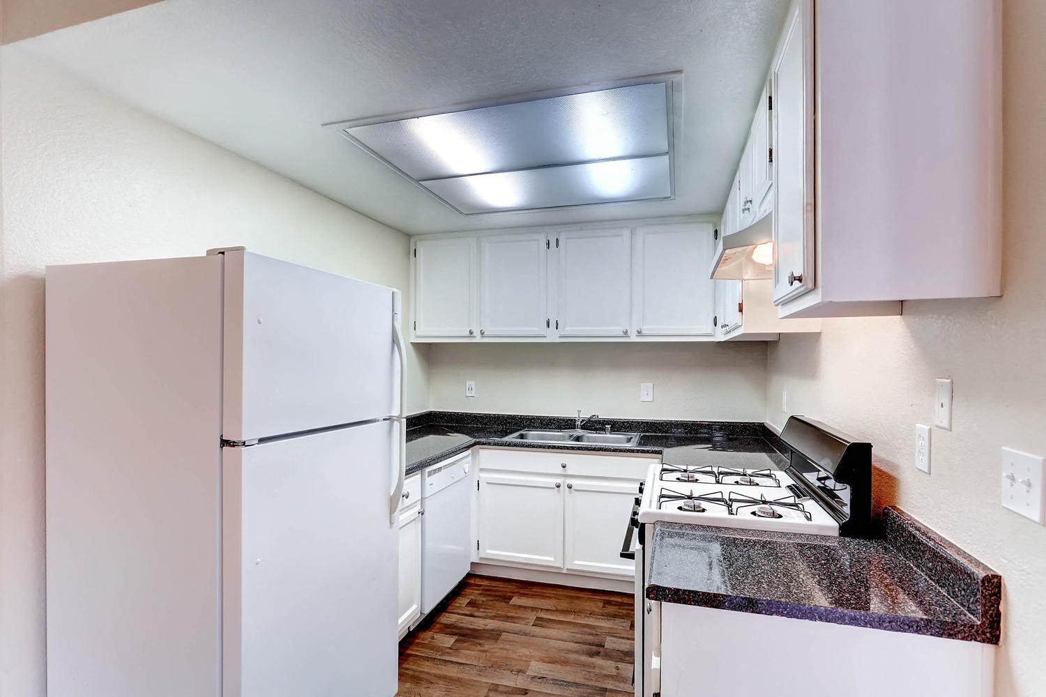 a kitchen with white cabinets and a white refrigerator
