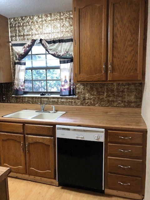 A kitchen with wooden cabinets and a black dishwasher.