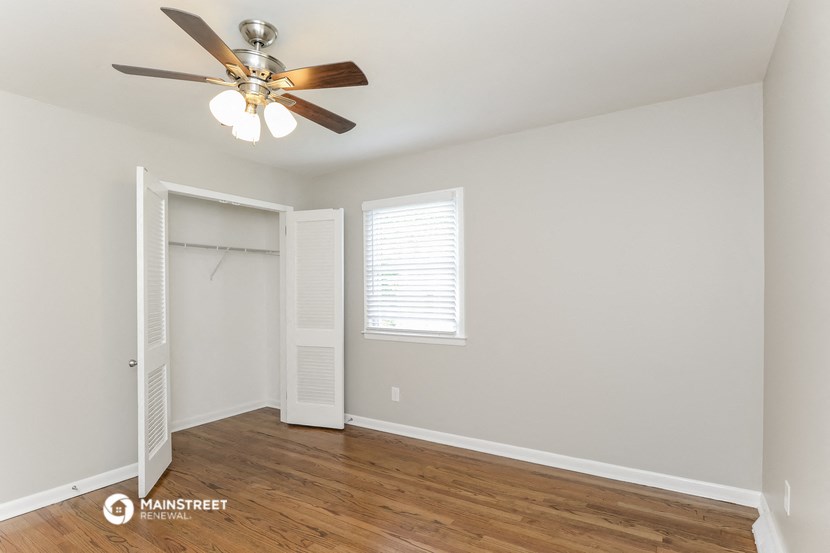a bedroom with a ceiling fan and a closet