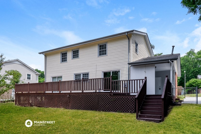 a white house with a deck and a fence