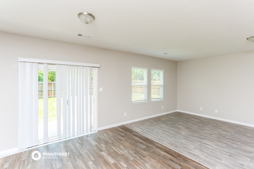the spacious living room with sliding glass doors to the patio