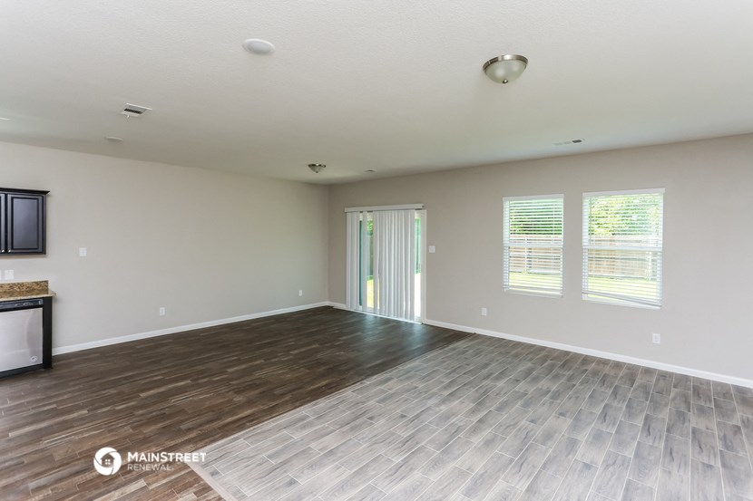 the spacious living room with wood flooring and sliding glass doors