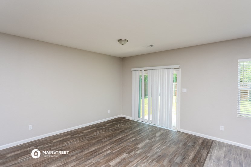 the spacious living room with sliding glass doors to the patio