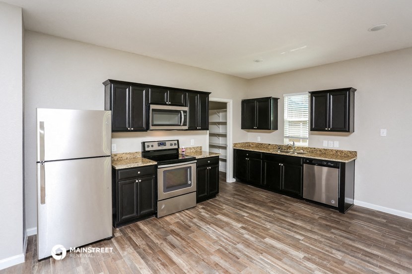 a kitchen with black cabinets and stainless steel appliances