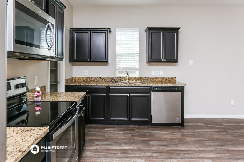 a kitchen with black cabinets and granite counter tops