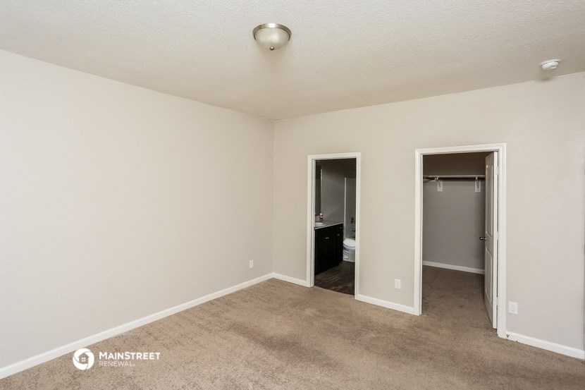 an empty living room with a closet and a bathroom
