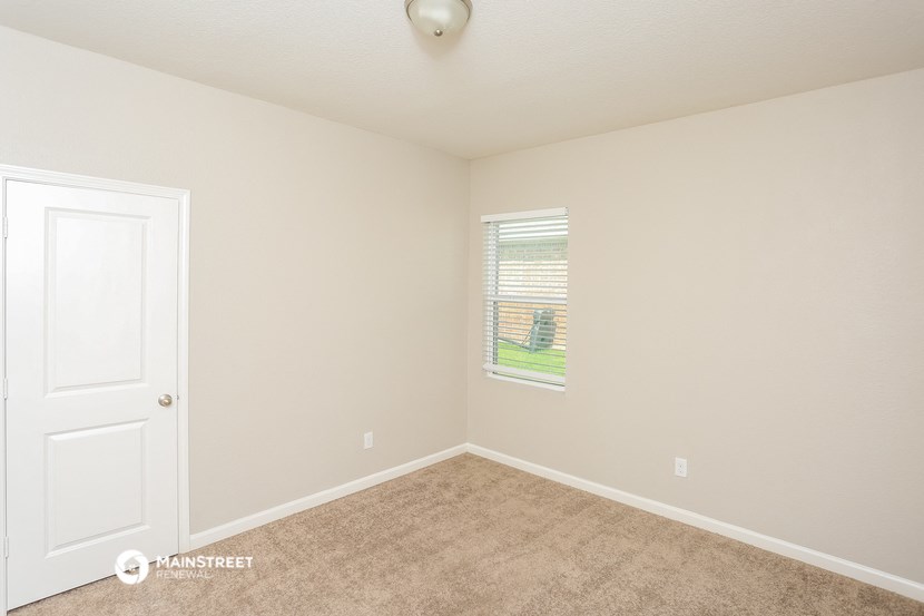 an empty room with a door and a window