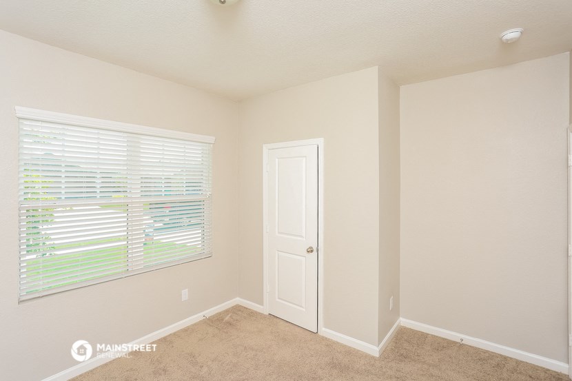 a bedroom with a large window and a white door