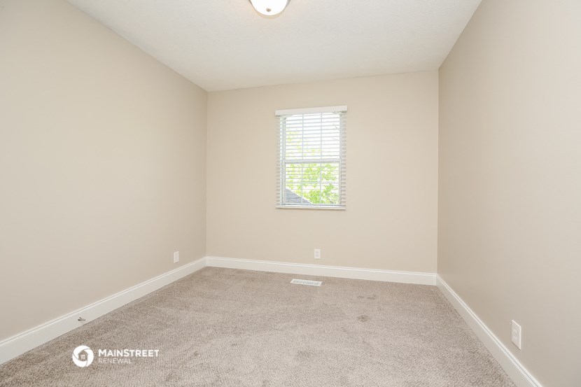an empty room with carpet and a window