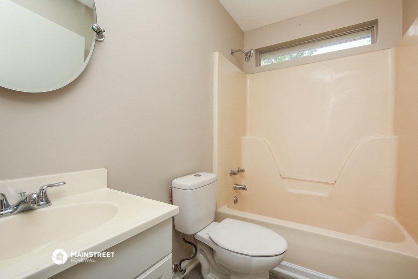 a bathroom with a toilet and a sink and a tub