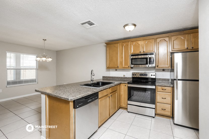 a kitchen with wooden cabinets and stainless steel appliances