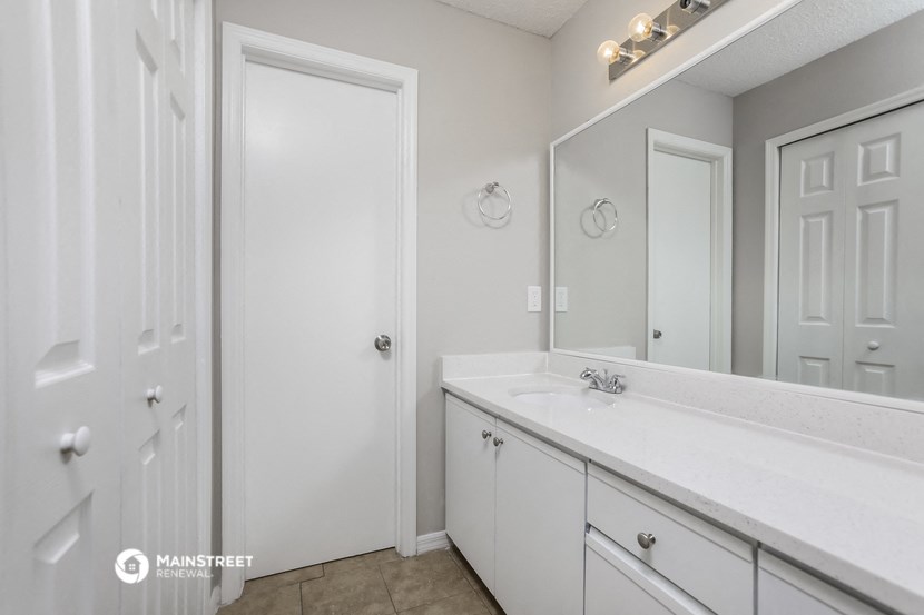 a bathroom with a sink and a mirror and a closet