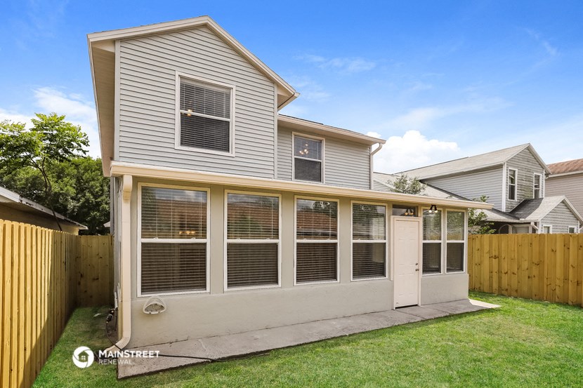 the back of a house with a garage and a yard with a fence