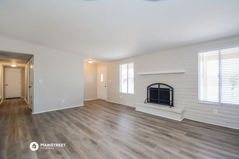the living room of an apartment with a fireplace and wooden floors