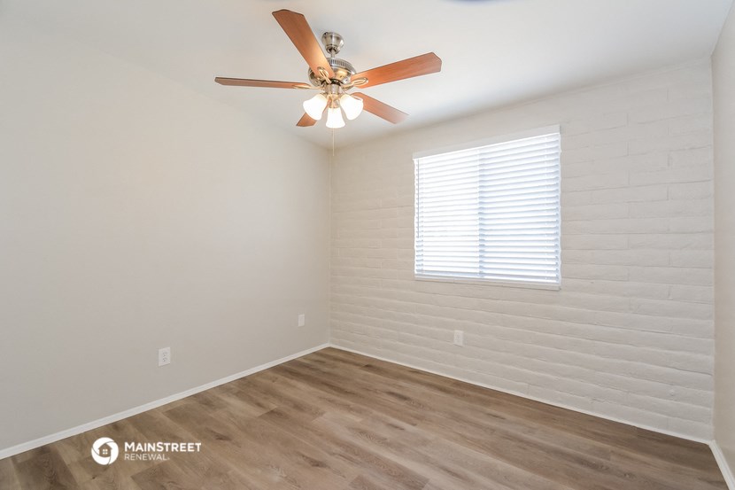 a bedroom with a ceiling fan and a window