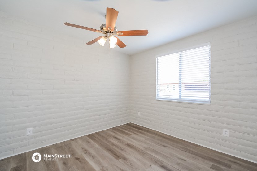 a bedroom with a ceiling fan and a window