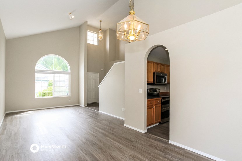 an open living room and kitchen with a large arched door and a window
