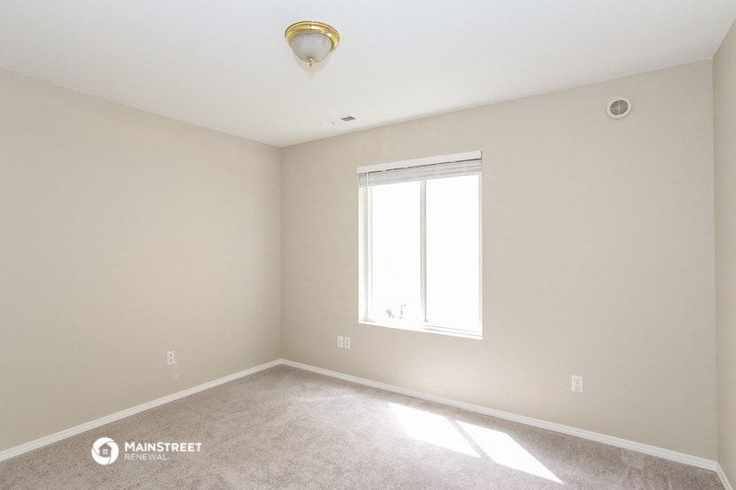 a empty room with a window and a ceiling fan