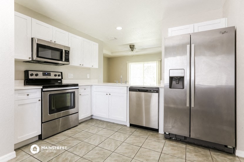 a kitchen with stainless steel appliances and white cabinets