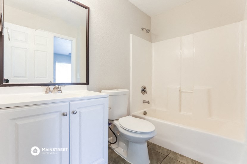 a bathroom with a toilet and a tub and a sink